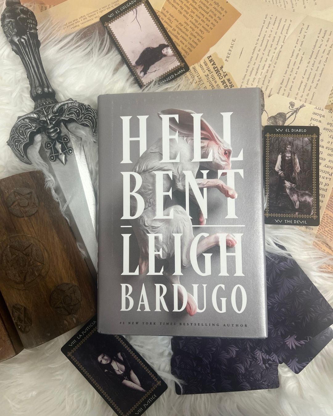 Hell Bent by Leigh Bardugo, displayed with Gothic tarot cards, an ornate dagger and occult decorations in a dark academia books flat lay.